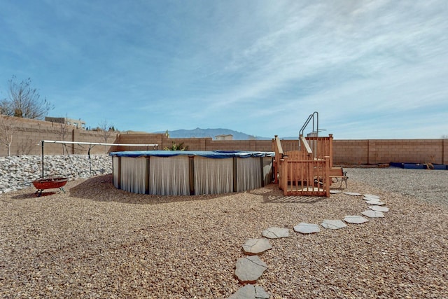 view of yard featuring a fenced in pool, a mountain view, and a fenced backyard