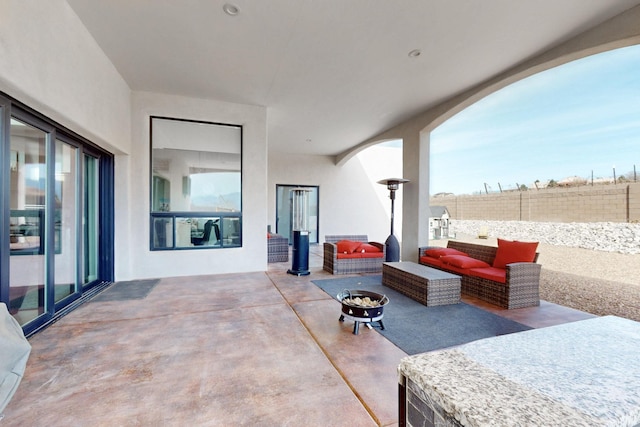 view of patio featuring an outdoor fire pit and fence