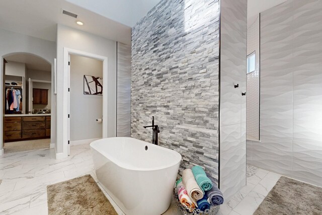 5721 Rio Animas Rd NE, Rio Rancho, NM 87144 - bathroom featuring a freestanding bath, walk in shower, a walk in closet, marble finish floors, and recessed lighting