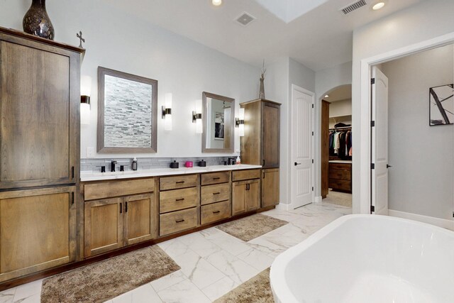 5721 Rio Animas Rd NE, Rio Rancho, NM 87144 - full bathroom with marble look tiles, a soaking tub, double vanity, recessed lighting, and a walk in closet