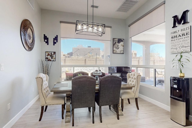 dining area with an inviting chandelier, wood finished floors, visible vents, and baseboards