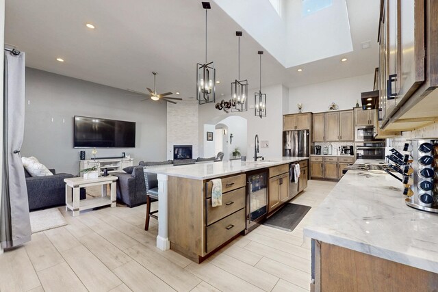 5721 Rio Animas Rd NE, Rio Rancho, NM 87144 - kitchen featuring a towering ceiling, wine cooler, ceiling fan, open floor plan, and stainless steel appliances