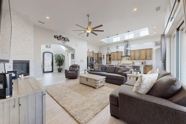 5721 Rio Animas Rd NE, Rio Rancho, NM 87144 - living room with a ceiling fan, arched walkways, a stone fireplace, light wood-style floors, and recessed lighting