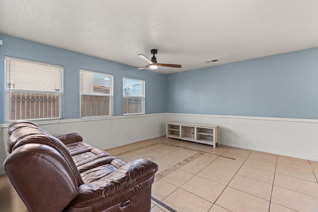 sitting room featuring a wealth of natural light, visible vents, a textured ceiling, and light tile patterned floors