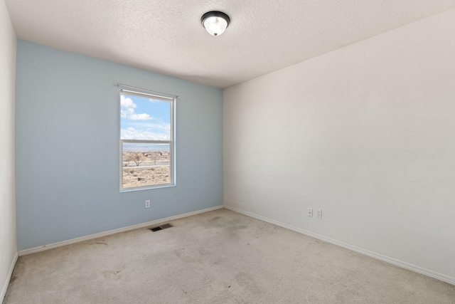 carpeted empty room with visible vents, baseboards, and a textured ceiling