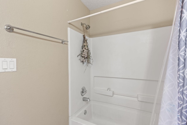 full bath with a textured ceiling and shower / tub combo with curtain