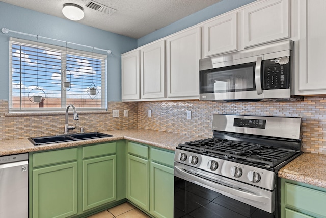 kitchen with tasteful backsplash, visible vents, light countertops, appliances with stainless steel finishes, and a sink