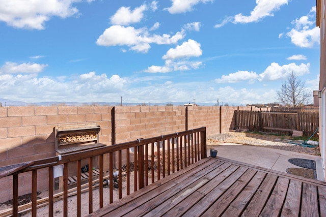 wooden deck featuring an outdoor fire pit, a fenced backyard, and a patio area