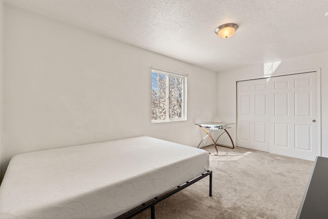 bedroom with a closet, carpet, and a textured ceiling