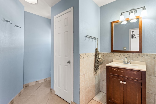 full bathroom featuring tile patterned flooring, tile walls, vanity, and a ceiling fan