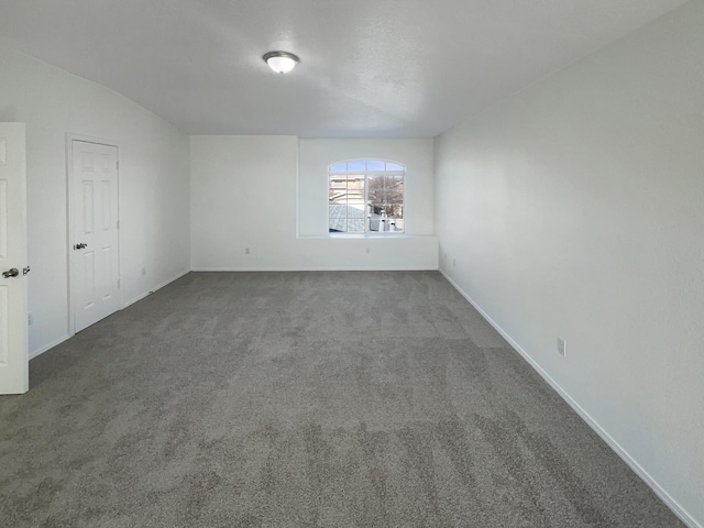 empty room featuring carpet flooring and baseboards