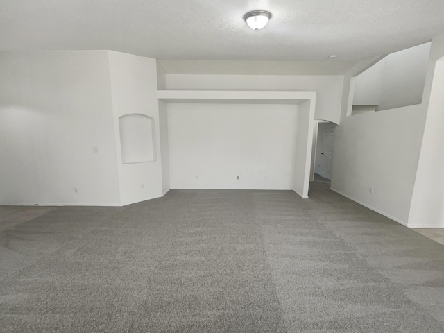 spare room with a textured ceiling and carpet flooring