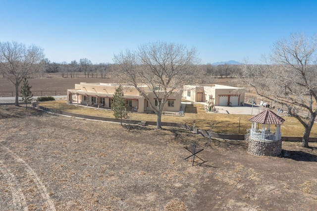 back of property featuring a gazebo, fence, driveway, and stucco siding