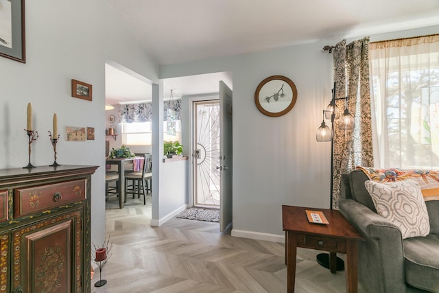 foyer featuring lofted ceiling and baseboards