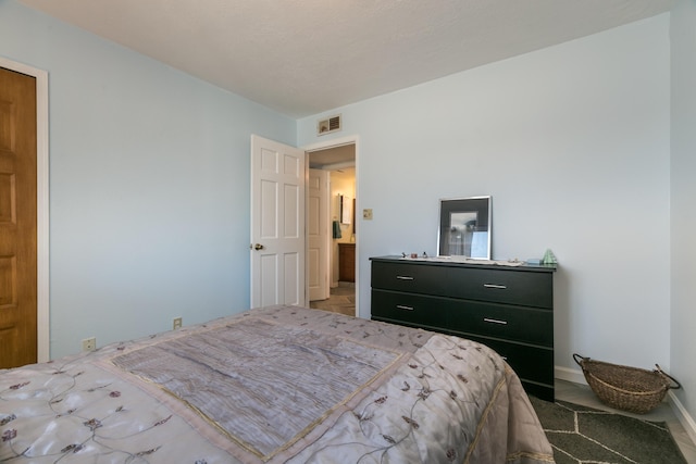 bedroom featuring baseboards and visible vents