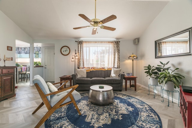 living area with ceiling fan, baseboards, and lofted ceiling