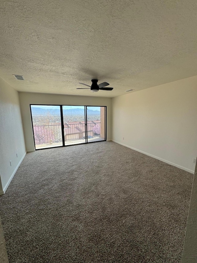 empty room featuring baseboards, visible vents, ceiling fan, a textured ceiling, and carpet flooring