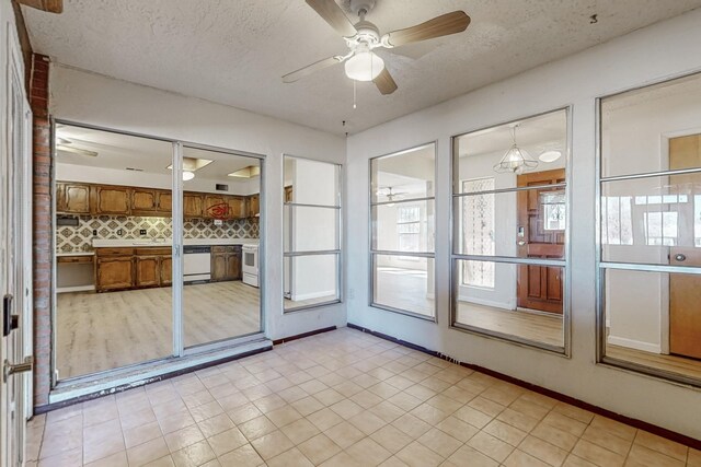 unfurnished sunroom featuring a ceiling fan