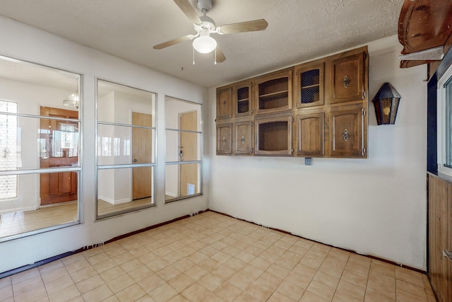 empty room featuring a textured ceiling and ceiling fan