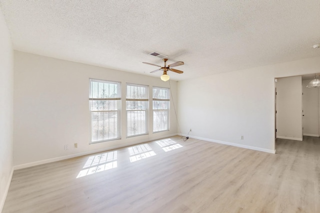 spare room with visible vents, baseboards, light wood-style floors, and a ceiling fan