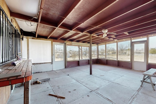 unfurnished sunroom featuring plenty of natural light and a ceiling fan