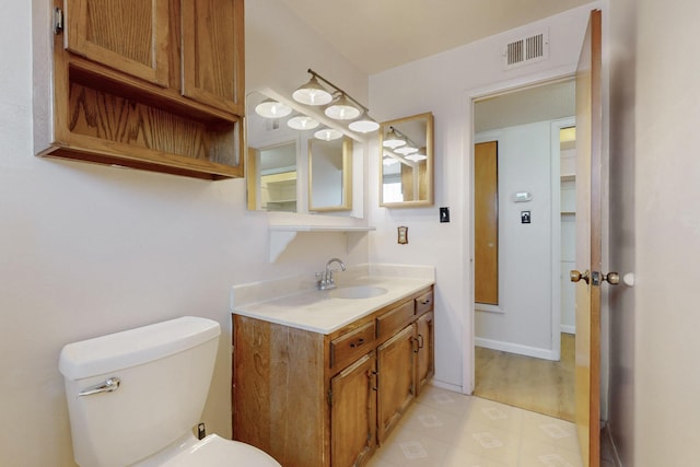 half bath featuring tile patterned floors, visible vents, toilet, and vanity