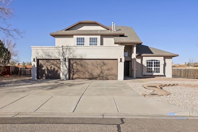 view of front facade with stucco siding, an attached garage, concrete driveway, and fence