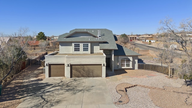 view of front of property featuring concrete driveway, a fenced backyard, a garage, and stucco siding