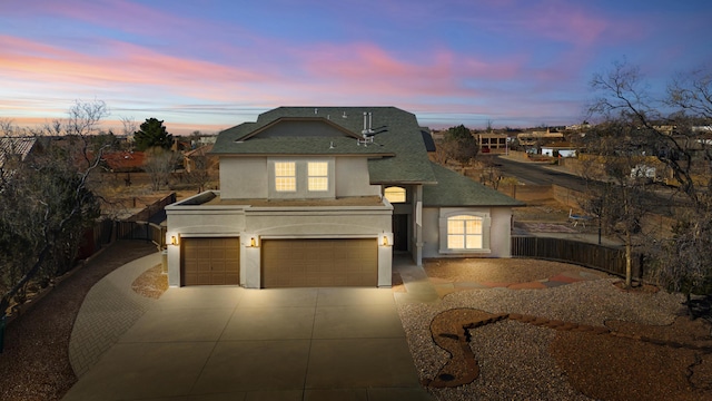 traditional-style house with stucco siding, driveway, and fence