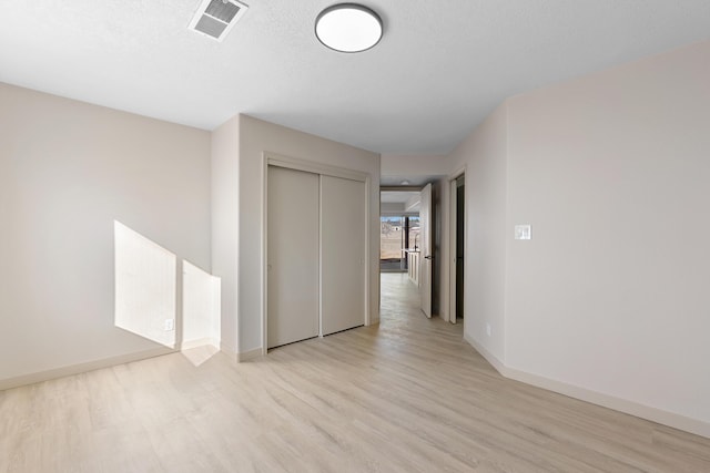 unfurnished room featuring visible vents, baseboards, and wood finished floors