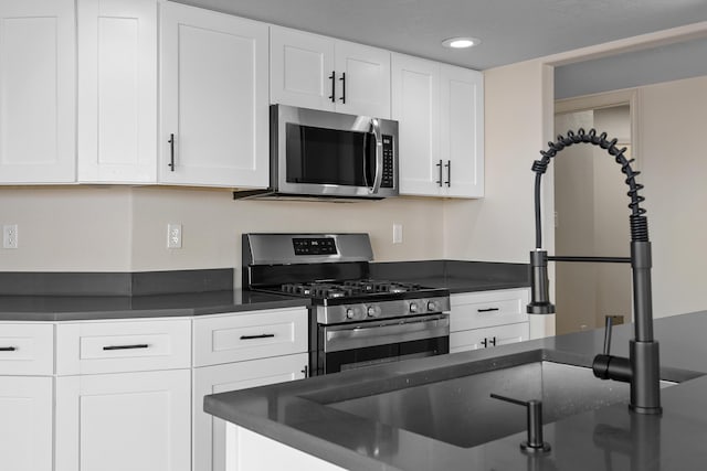 kitchen with recessed lighting, white cabinets, and stainless steel appliances