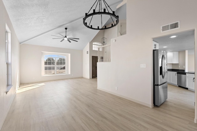 unfurnished living room with baseboards, visible vents, ceiling fan, light wood-style floors, and a textured ceiling