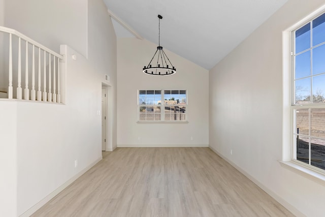 spare room with visible vents, high vaulted ceiling, wood finished floors, baseboards, and a chandelier