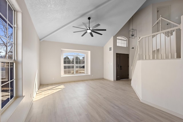 unfurnished living room featuring stairway, a ceiling fan, wood finished floors, visible vents, and a textured ceiling