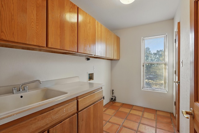 clothes washing area featuring light tile patterned floors, cabinet space, hookup for a washing machine, and a sink