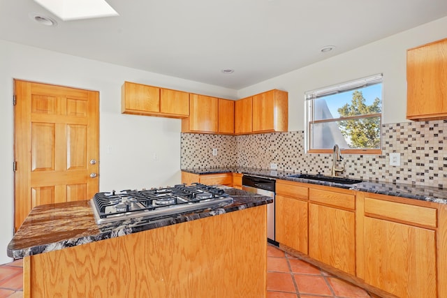 kitchen with light tile patterned floors, a kitchen island, a skylight, a sink, and appliances with stainless steel finishes