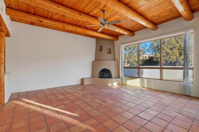 unfurnished living room with tile patterned floors, beamed ceiling, a ceiling fan, a fireplace, and wood ceiling