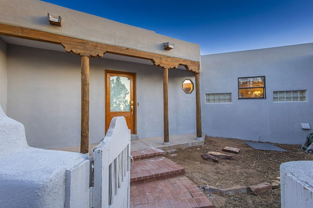 view of exterior entry with stucco siding