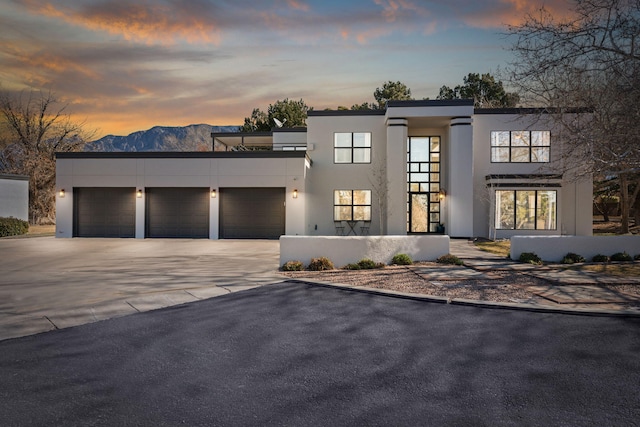 contemporary house with stucco siding, driveway, and an attached garage