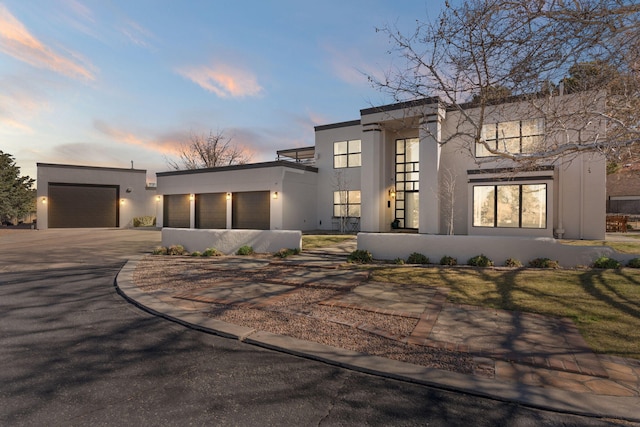 view of front of home featuring stucco siding, driveway, and a garage