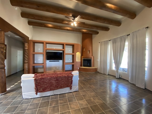 761 Marble Sky Ave NE, Rio Rancho, NM 87144 - living area with beamed ceiling, a ceiling fan, dark tile patterned floors, and a large fireplace