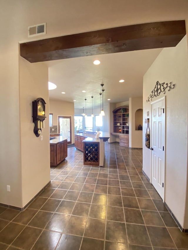 hall featuring visible vents, dark tile patterned flooring, recessed lighting, arched walkways, and beamed ceiling