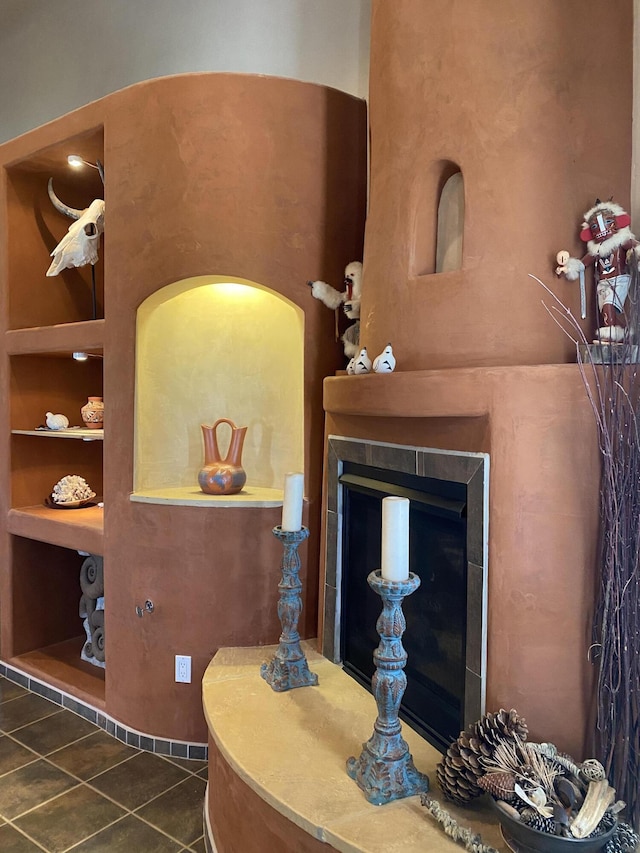 room details featuring a fireplace with raised hearth and built in shelves