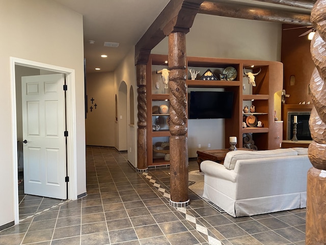 tiled living room featuring a glass covered fireplace, recessed lighting, and decorative columns