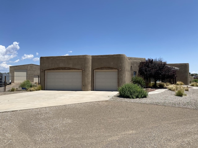 761 Marble Sky Ave NE, Rio Rancho, NM 87144 - adobe home with a garage, driveway, and stucco siding