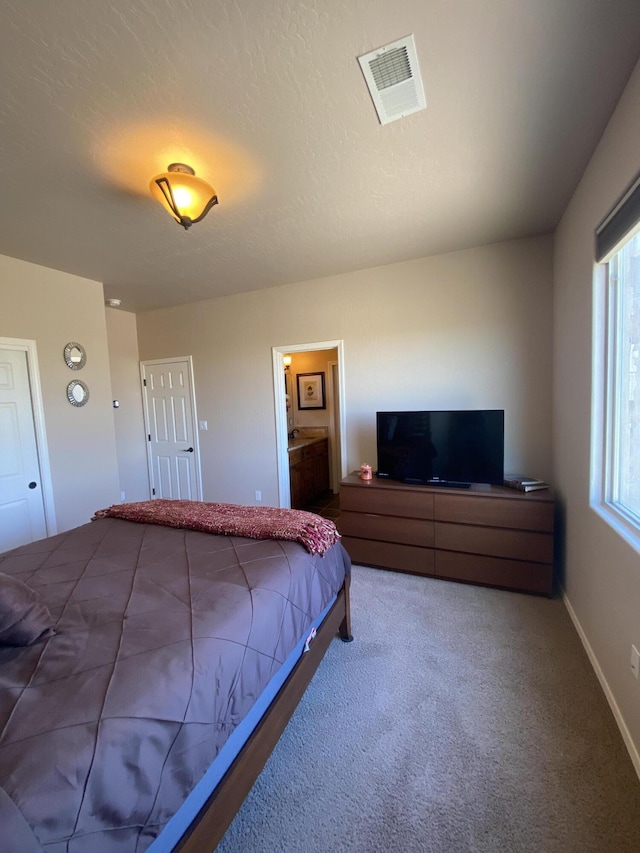 bedroom featuring visible vents, a textured ceiling, baseboards, and carpet floors