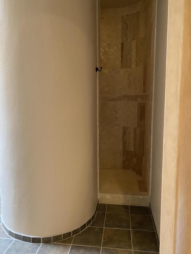 full bath with a tile shower and tile patterned flooring