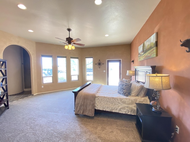 carpeted bedroom featuring arched walkways, recessed lighting, baseboards, and ceiling fan