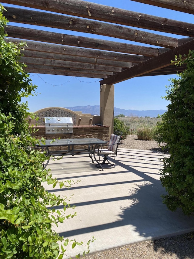 view of patio / terrace with grilling area, a mountain view, and a pergola