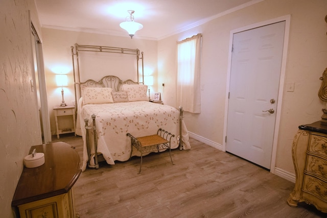 bedroom with baseboards, light wood-style floors, and ornamental molding